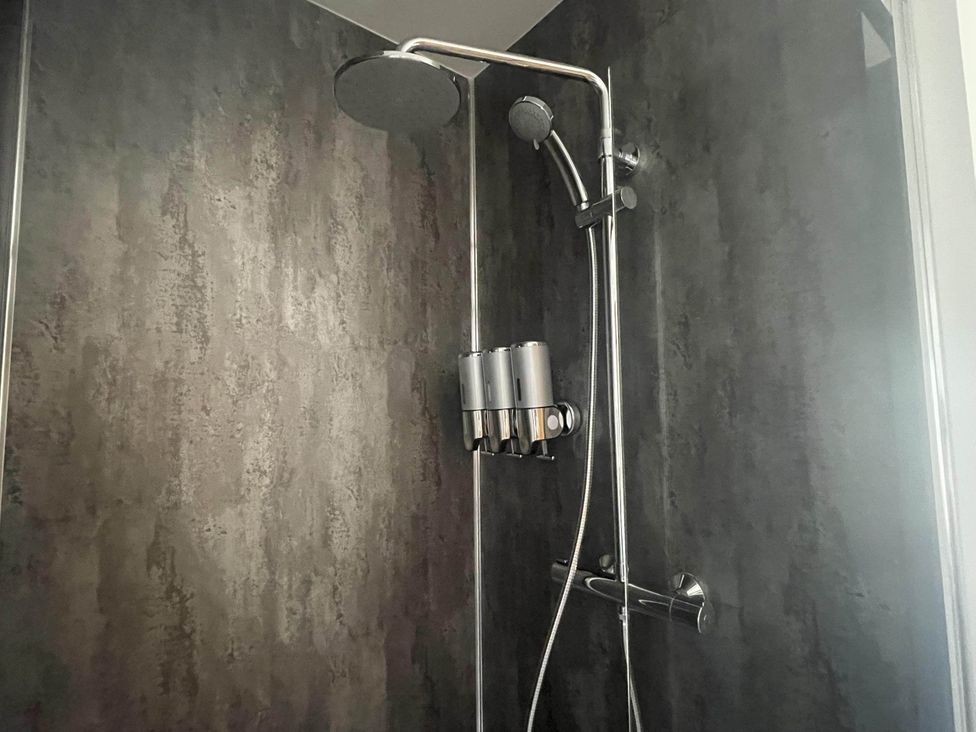 A shower with a wall-mounted soap dispenser at Stylish NC500 base with panoramic views in Inverness
