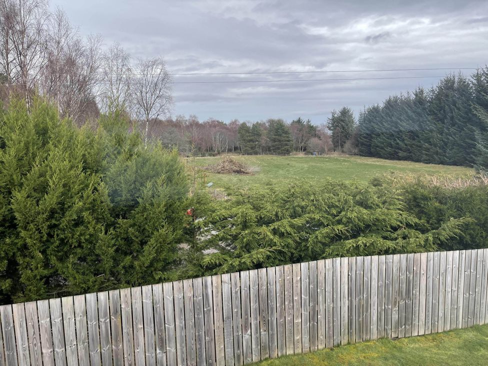 An outdoor view with a fence and trees at Stylish NC500 base with panoramic views in Inverness