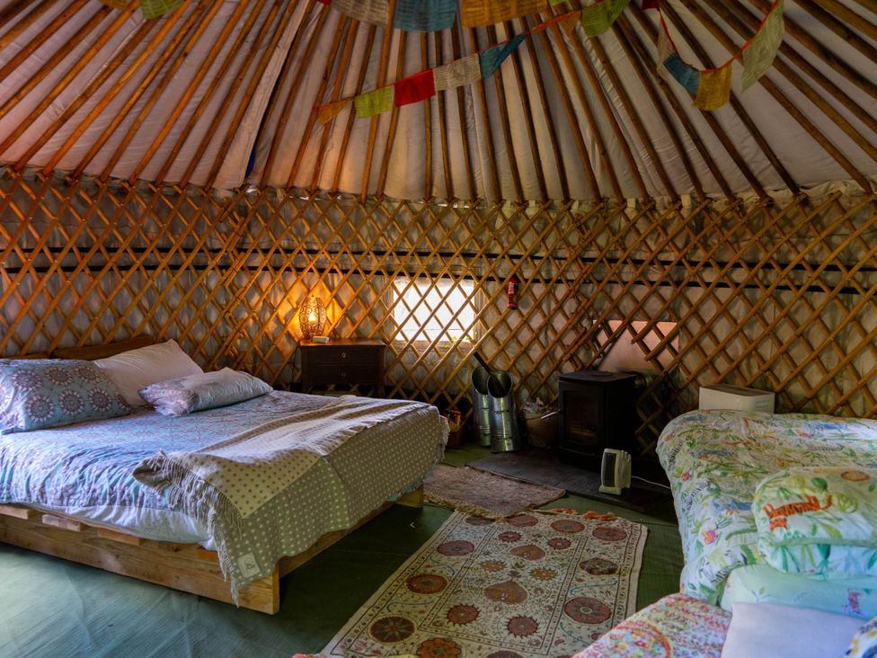 A bedroom with beds and a wood stove at Hapus Yurt - Two Beautiful Yurts and Barn Cottage