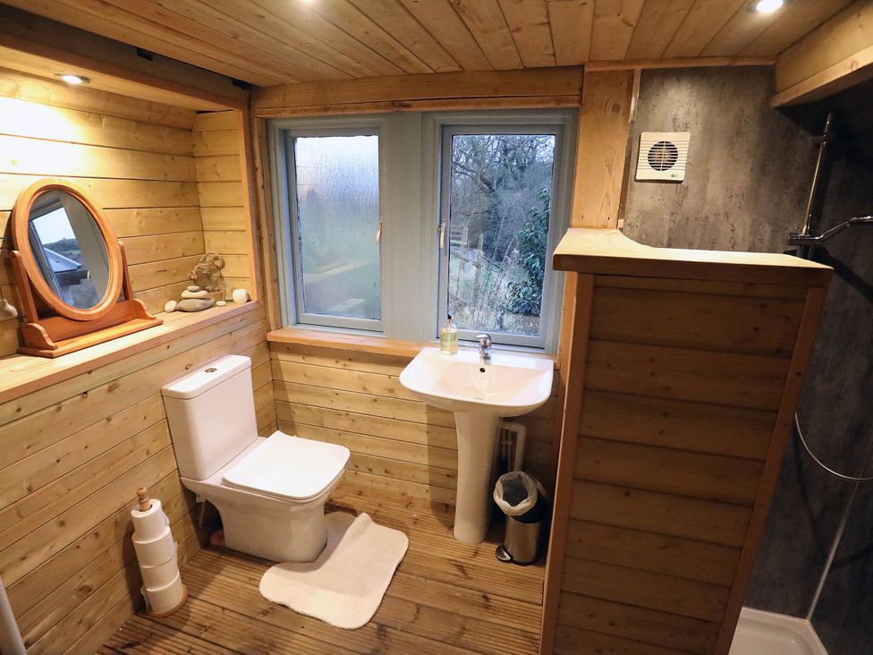A bathroom with a toilet, sink, and mirror at Hapus Yurt - Two Beautiful Yurts and Barn Cottage