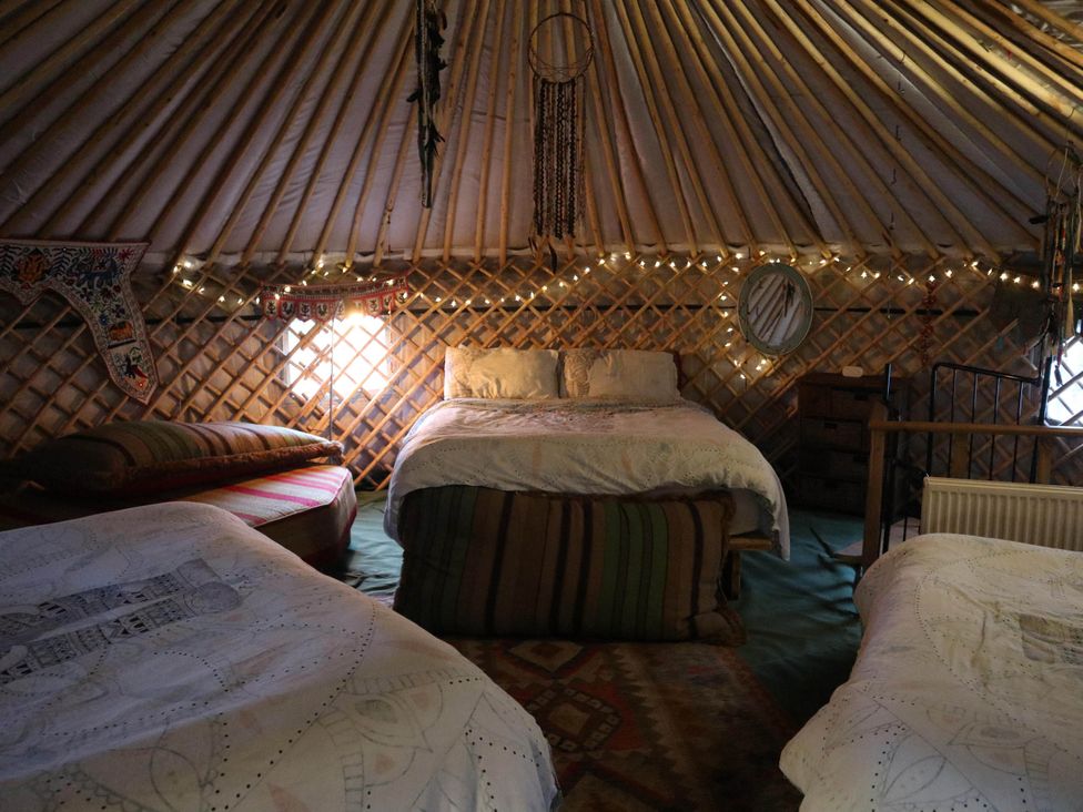 A bedroom with beds and a mirror at Hapus Yurt - Two Beautiful Yurts and Barn Cottage