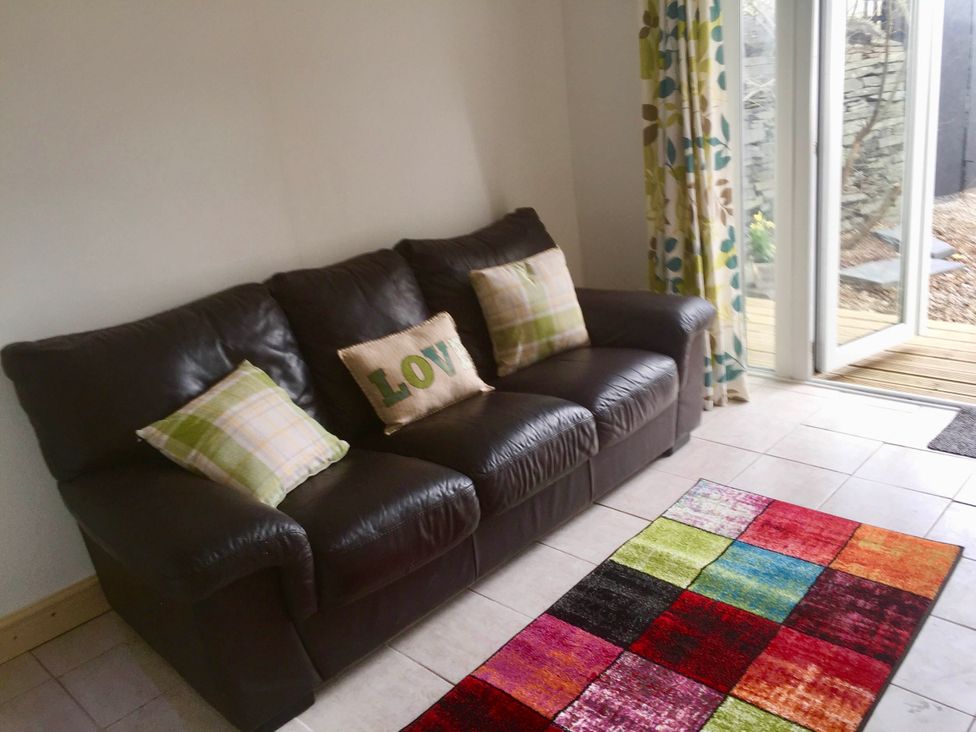 A living room with a sofa and rug at Zip Cottage Sleeps 2-3 climb snowdon zip world