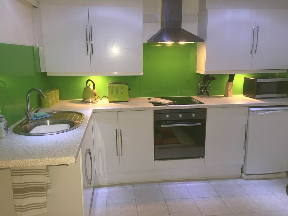 A kitchen with a sink, kettle, oven, and microwave at Zip Cottage Sleeps 2-3 climb snowdon zip world