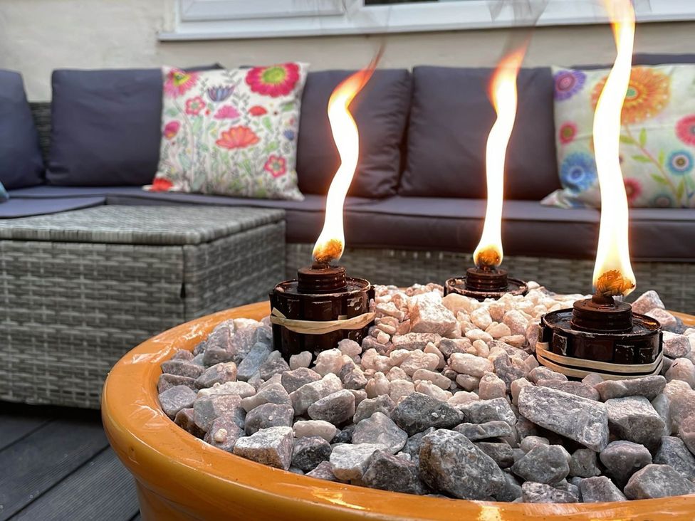 An outdoor lounge area with a fire pit and seating at Zip Cottage Sleeps 2-3 climb snowdon zip world