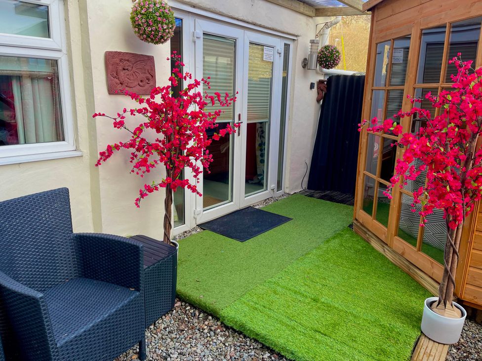 An outdoor area with faux grass and flowering plants at Zip Cottage Sleeps 2-3 climb snowdon zip world