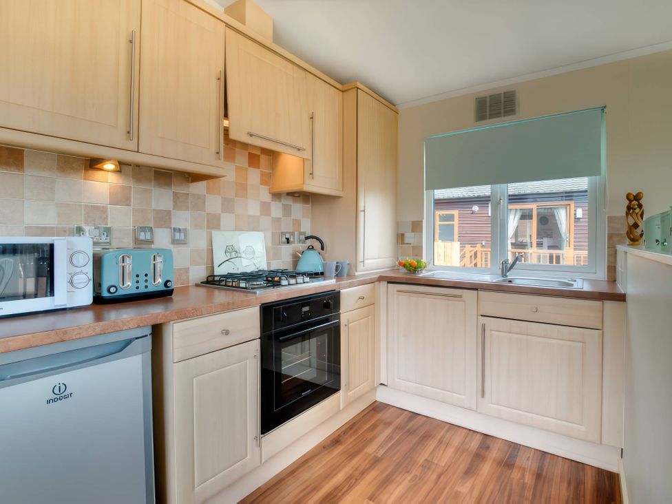 A kitchen with appliances and a window at Pet-friendly lodge with hot tub near the coast