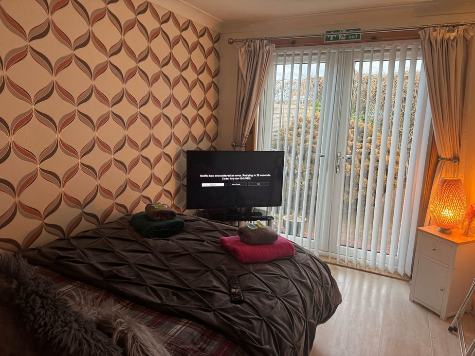 A bedroom with a bed and a television at Spacious family base with garden near Loch Ness