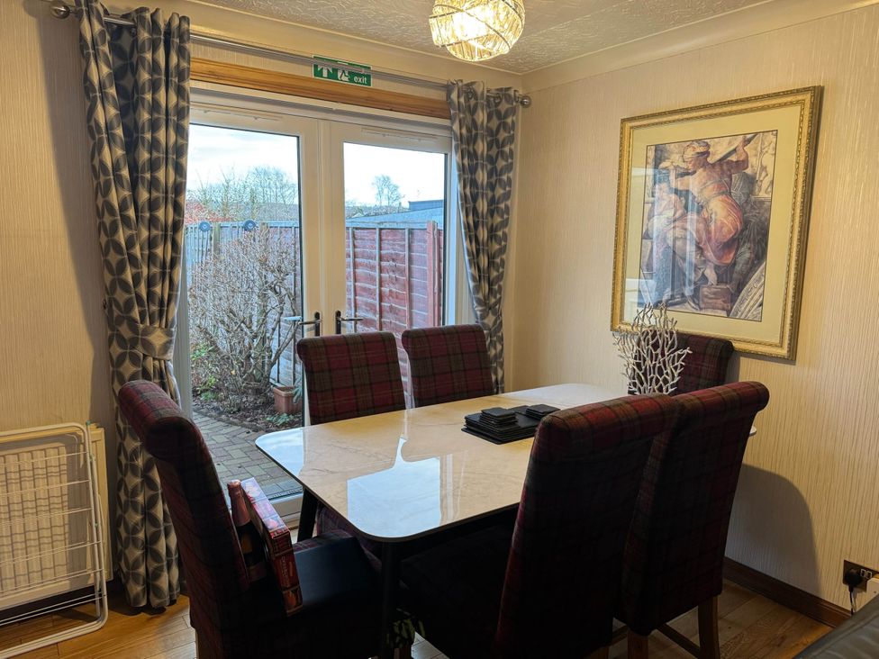 A dining room with a table and chairs at Spacious family base with garden near Loch Ness