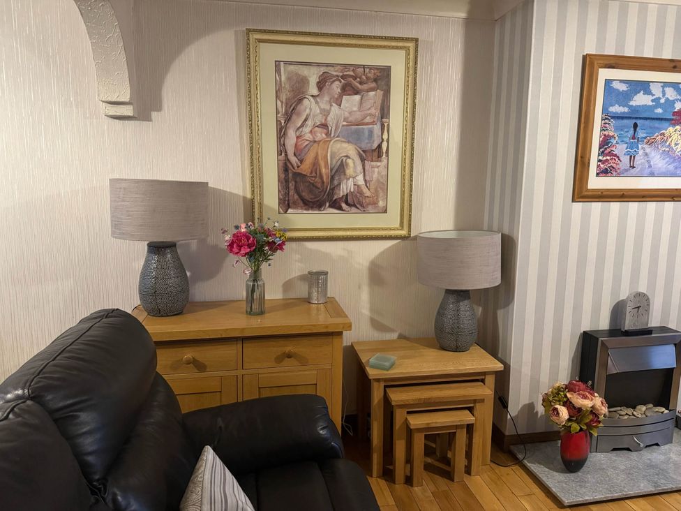 A living room with art on wall and lamps on tables at Spacious family base with garden near Loch Ness