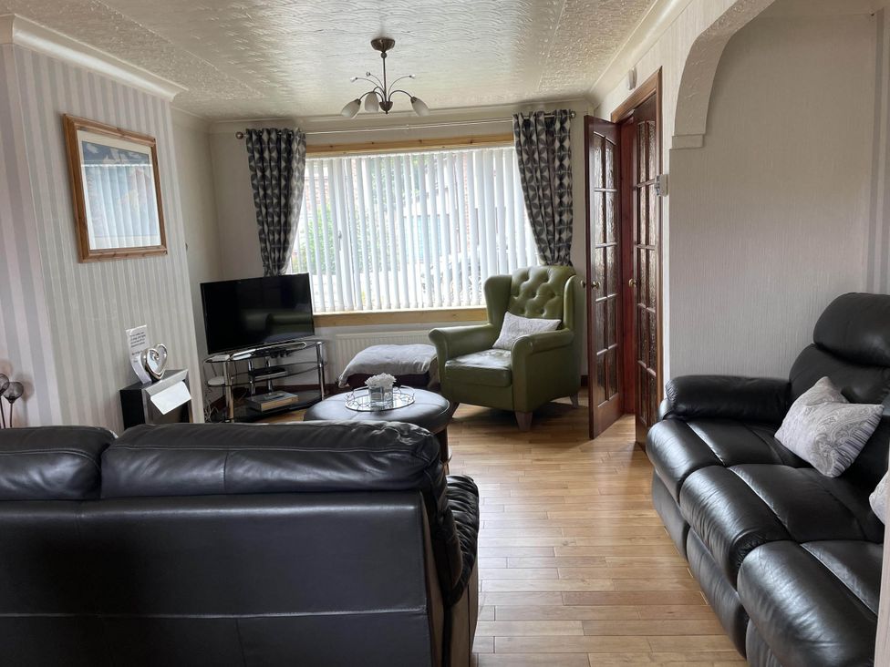 A living room with a television and seating area at Spacious family base with garden near Loch Ness