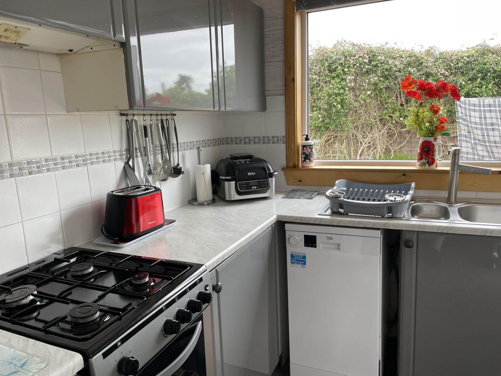 A kitchen with various appliances including a stove and toaster at Spacious family base with garden near Loch Ness