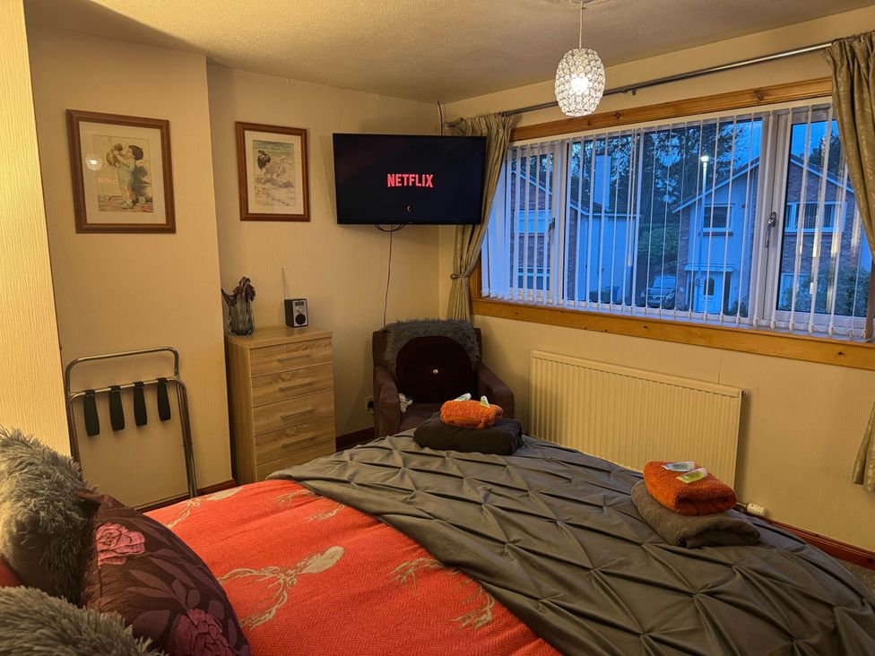 A bedroom with a bed and a television at Spacious family base with garden near Loch Ness