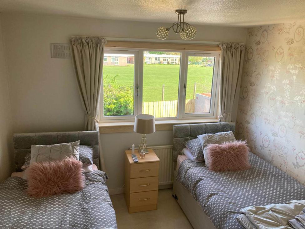 A bedroom with two beds and a window at Spacious family base with garden near Loch Ness