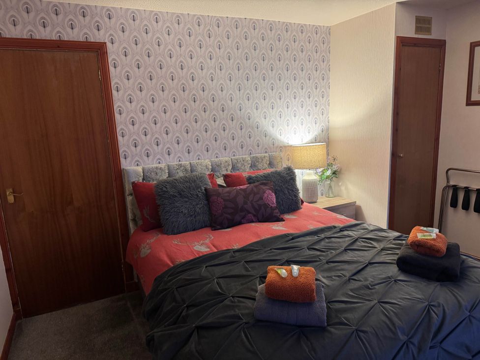 A bedroom with a bed and pillows at Spacious family base with garden near Loch Ness