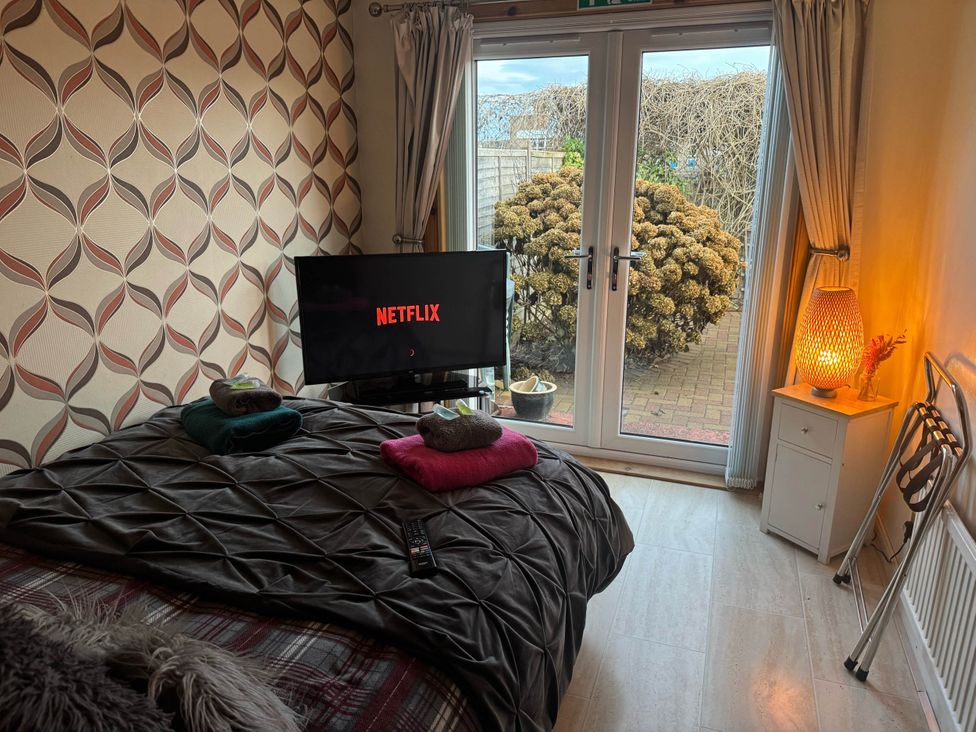 A bedroom with a bed and television at Spacious family base with garden near Loch Ness