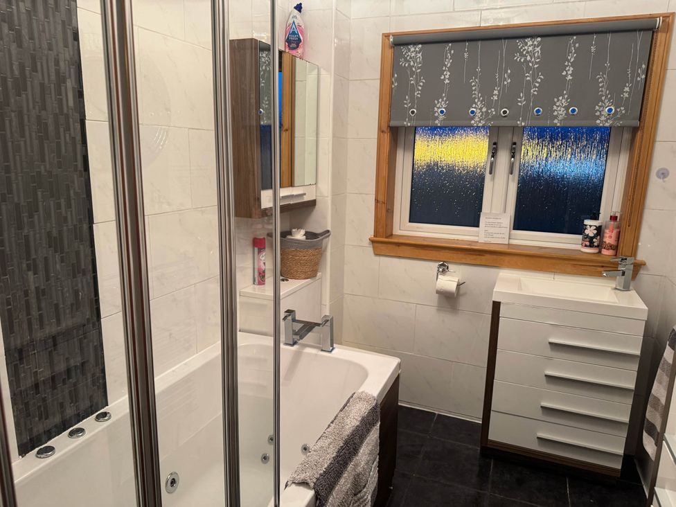 A bathroom with a bathtub and sink at Spacious family base with garden near Loch Ness