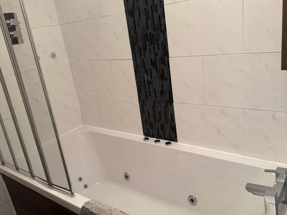 A bathroom with a bathtub and shower at Spacious family base with garden near Loch Ness