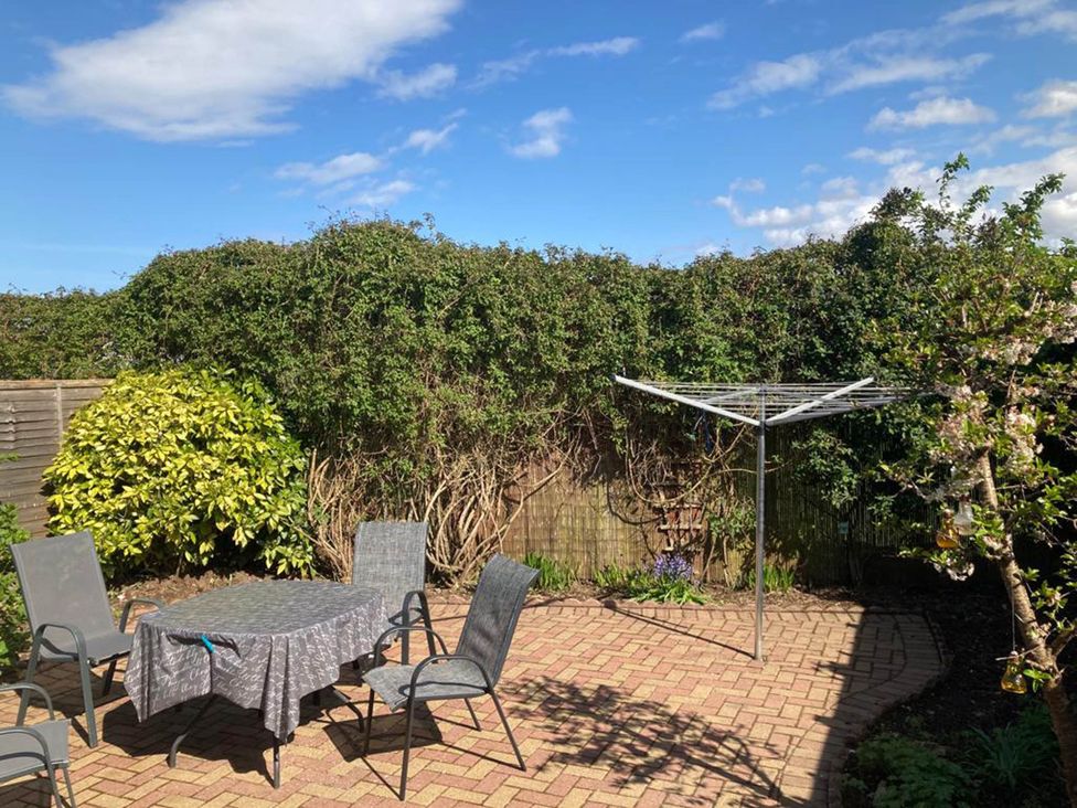 A garden with a table and chairs near a clothes line at Spacious family base with garden near Loch Ness