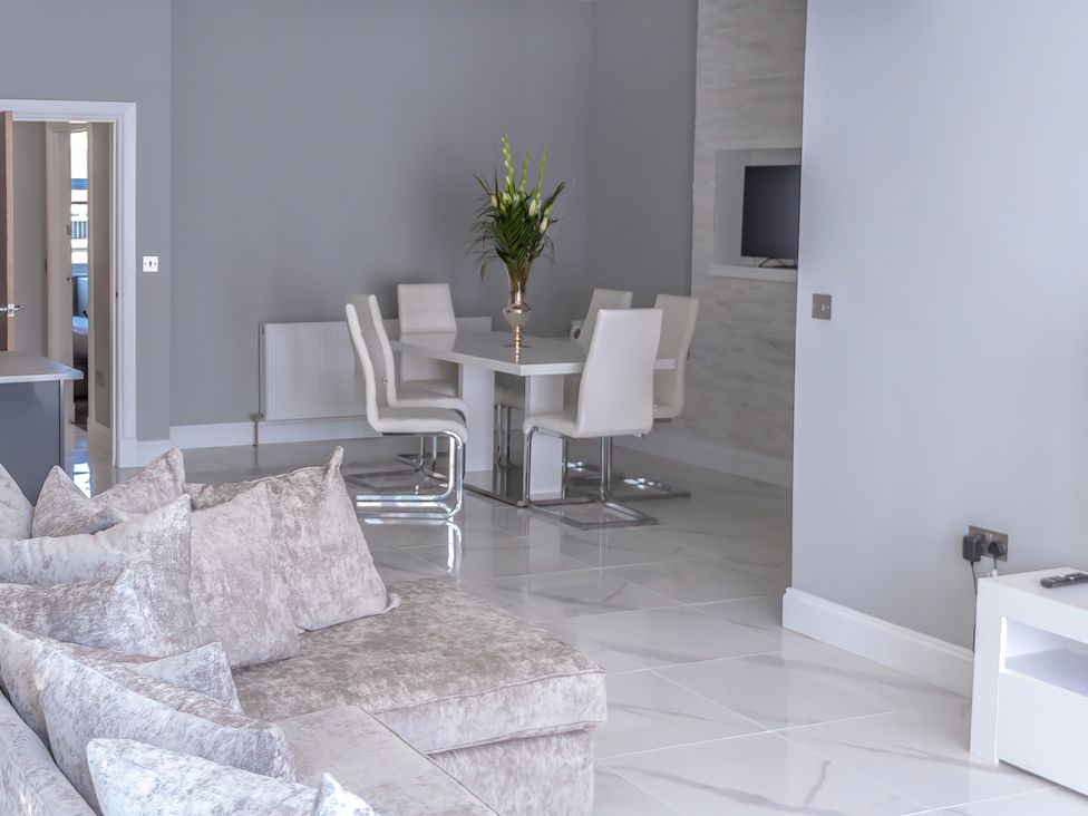 A living room with a sofa and dining area at Pet-friendly hot tub retreat near Loch Leven, Kelty