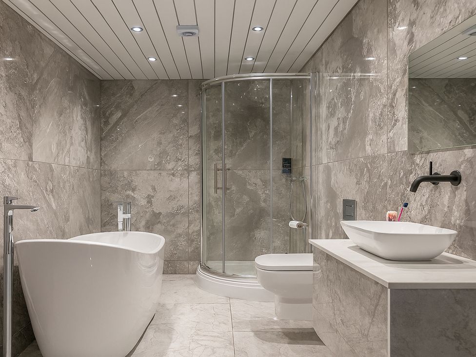 A bathroom with a shower, bathtub and sink at Pet-friendly hot tub retreat near Loch Leven