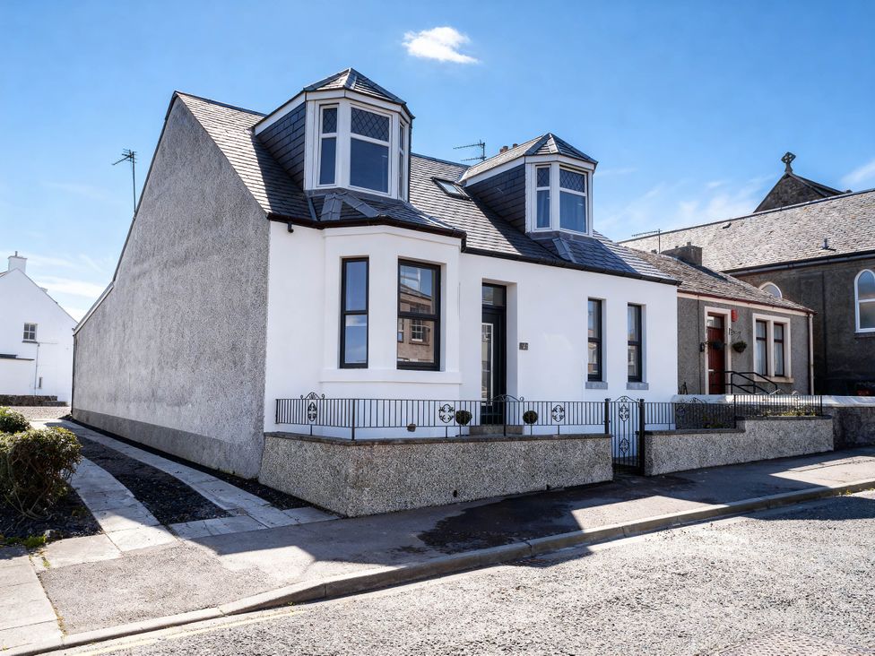 A house with multiple windows and fence at Pet-friendly hot tub retreat near Loch Leven, Kelty