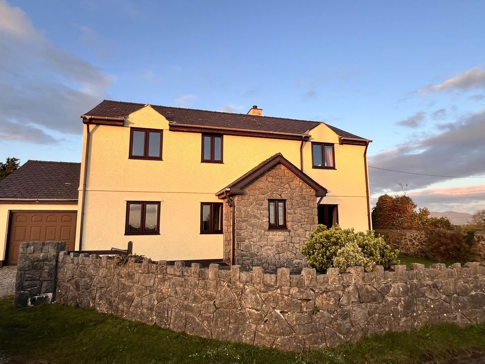 A house with a stone entrance and garage at Dog-friendly farmhouse with Menai Strait views
