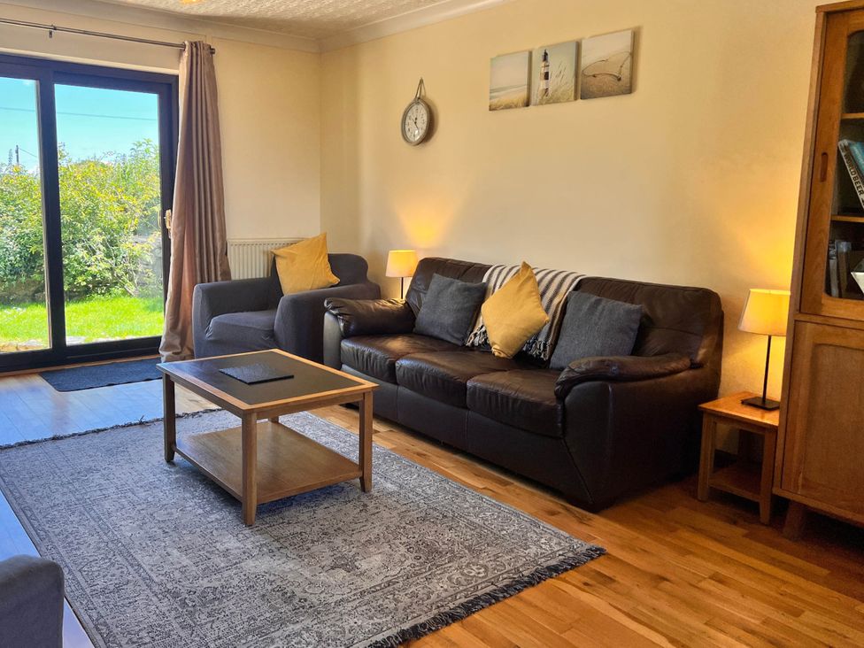 A living room with a sofa and coffee table at Dog-friendly farmhouse with Menai Strait views