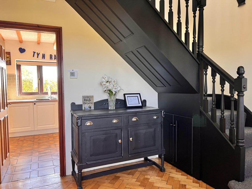 A hallway with a cupboard and staircase at Dog-friendly farmhouse with Menai Strait views