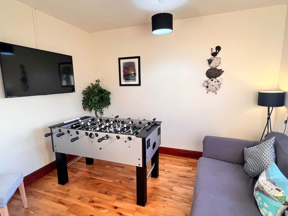 A game room with a foosball table and a television at Dog-friendly farmhouse with Menai Strait views
