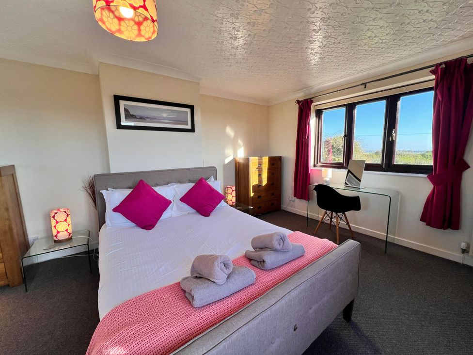 A bedroom with a bed and a desk at Dog-friendly farmhouse with Menai Strait views