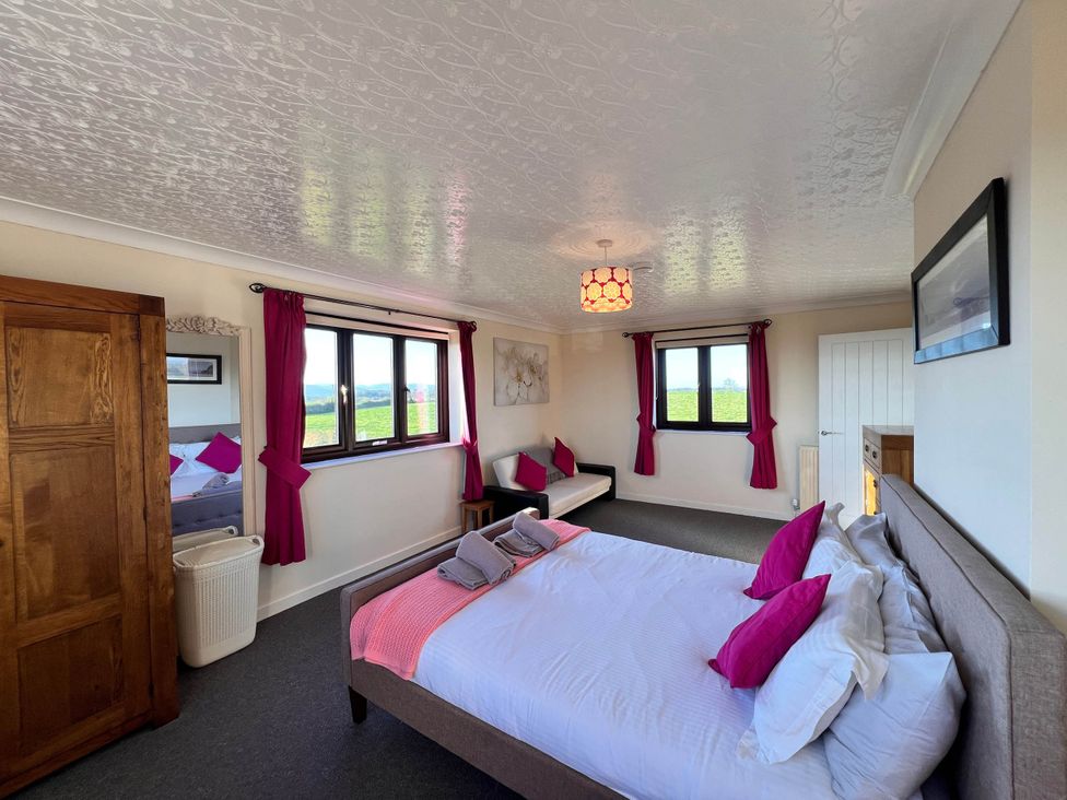 A bedroom with a bed and wardrobe at Dog-friendly farmhouse with Menai Strait views