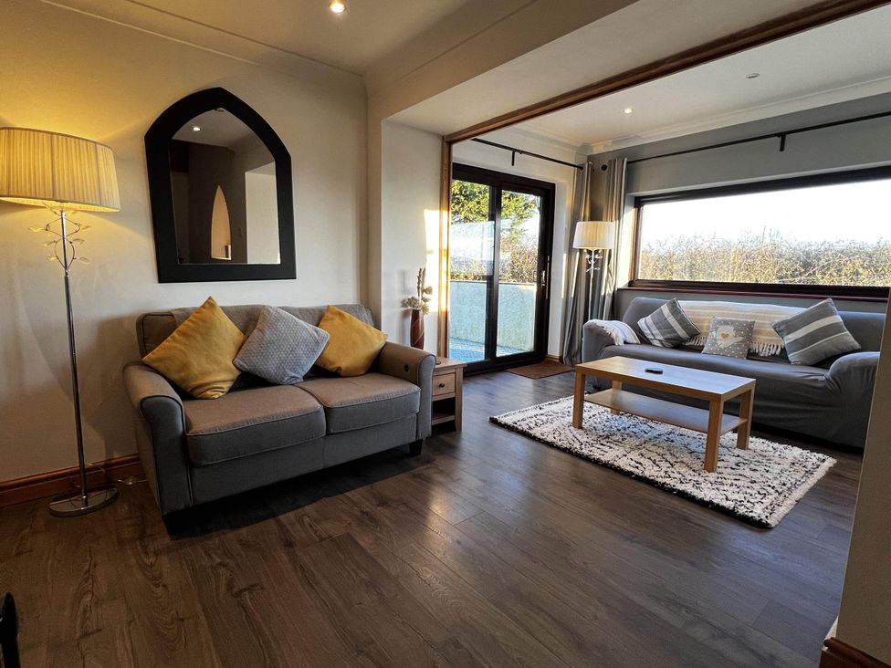 A living room with sofas and a coffee table at Cottage with mountain and sea views, Anglesey