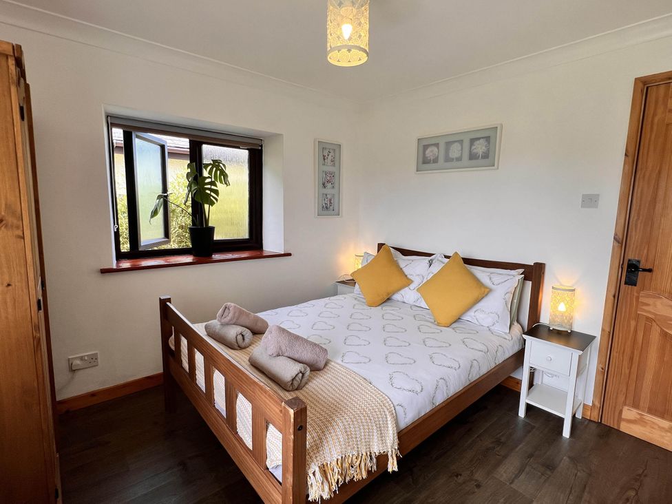 A bedroom with a bed and window at Cottage with mountain and sea views, Anglesey