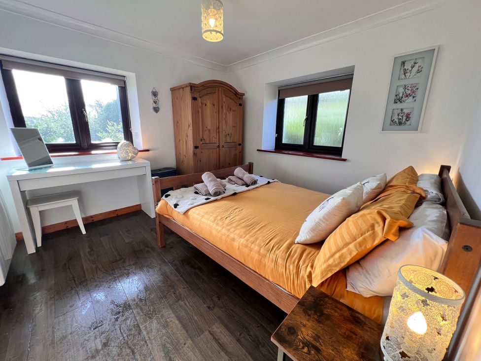 A bedroom with a bed and desk at Cottage with mountain and sea views, Anglesey