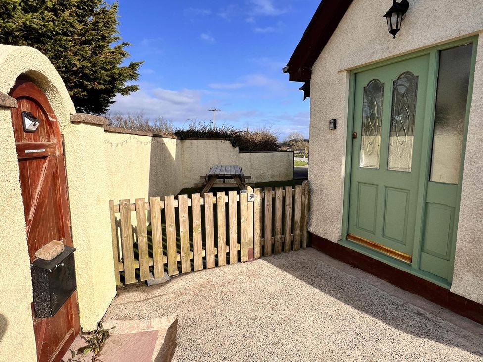 An outdoor entry with a gate and a table at Cottage with mountain and sea views, Anglesey