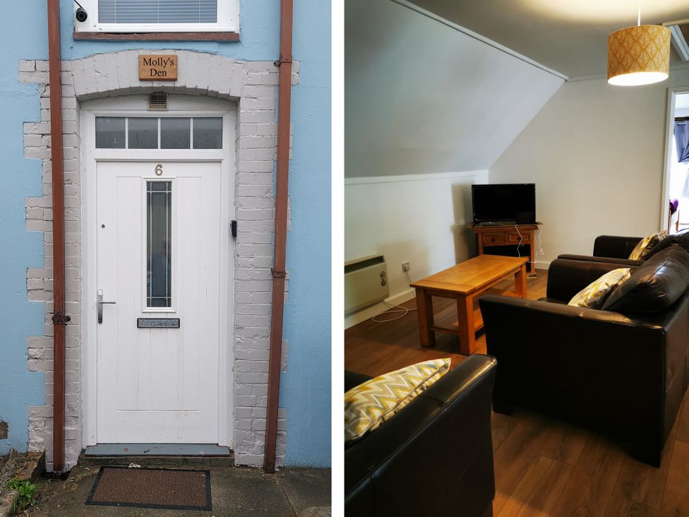 A living room with a tv and coffee table at Surf-ready apartment with sea views in town