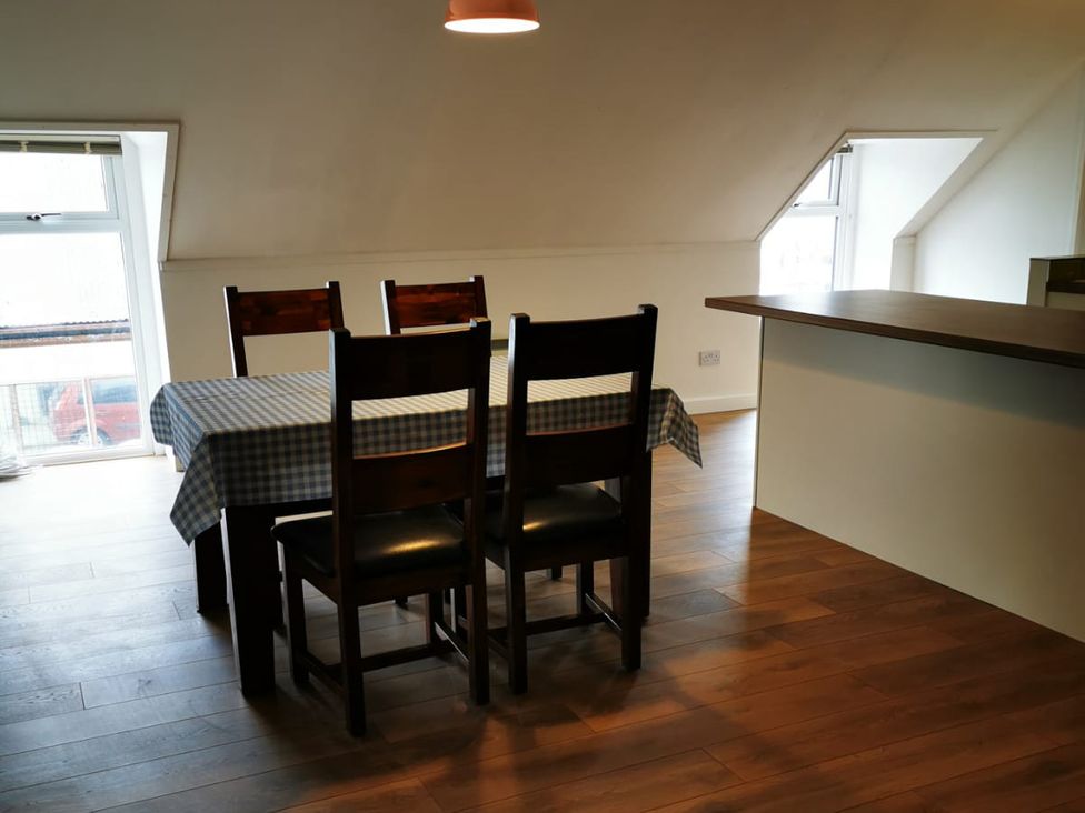 A dining room with a table and chairs in Surf-ready apartment with sea views in town