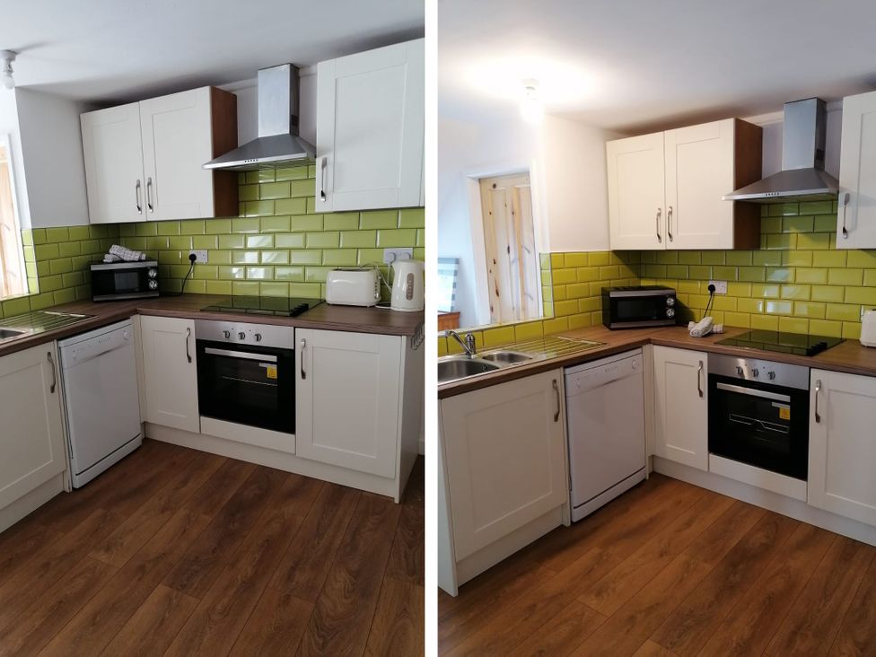 A kitchen with cabinets and appliances at Surf-ready apartment with sea views in town