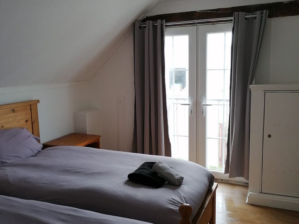 A bedroom with two beds and double doors in Surf-ready apartment with sea views in town