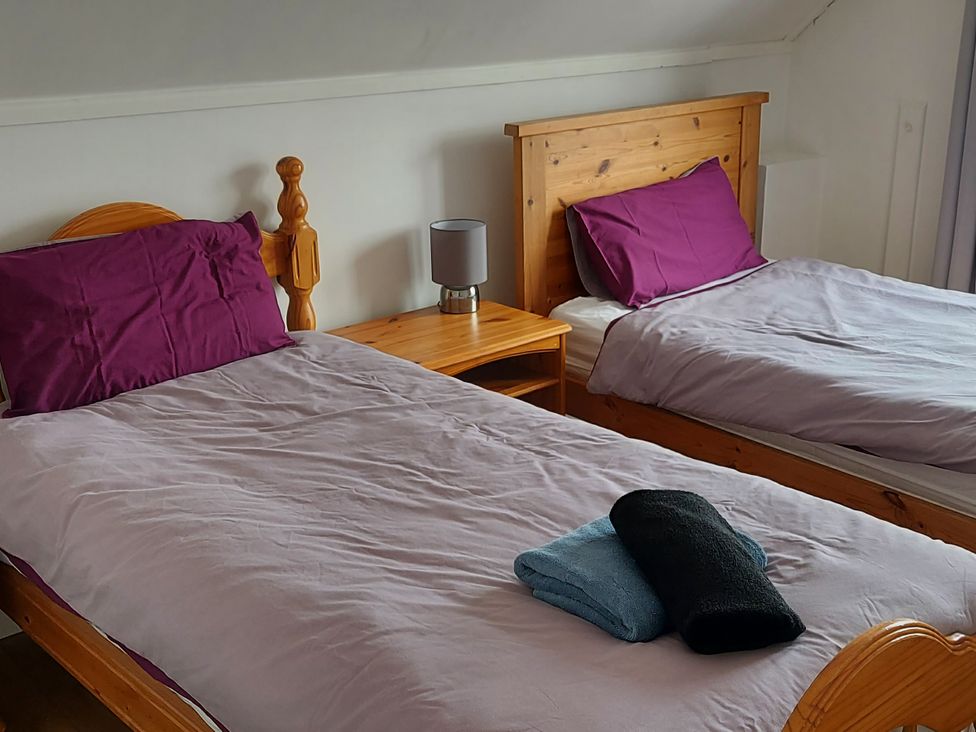 A bedroom with two beds and a nightstand at Surf-ready apartment with sea views in town