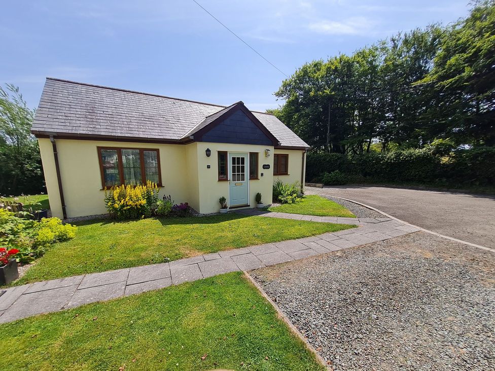 A house with a garden and pathway at Riverside cottage with otters near Tintagel
