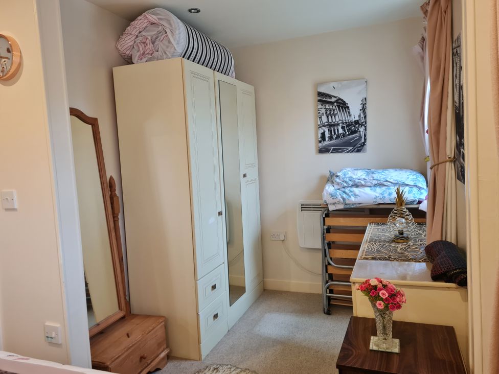 A bedroom with a bed and wardrobe at Riverside cottage with otters near Tintagel