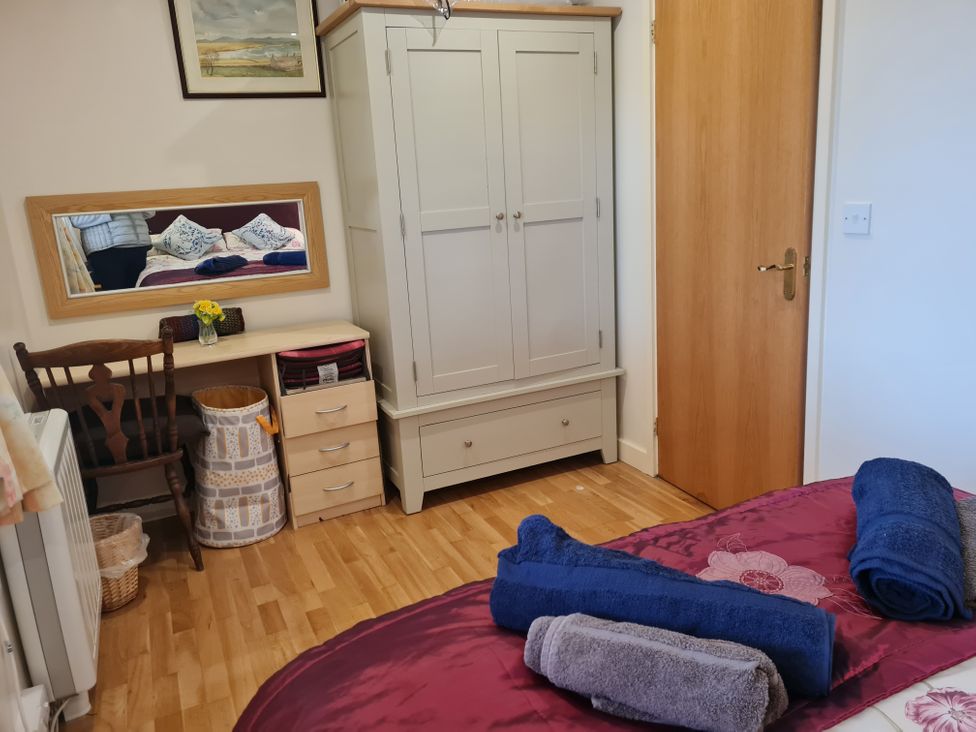 A bedroom with a bed and furniture at Riverside cottage with otters near Tintagel