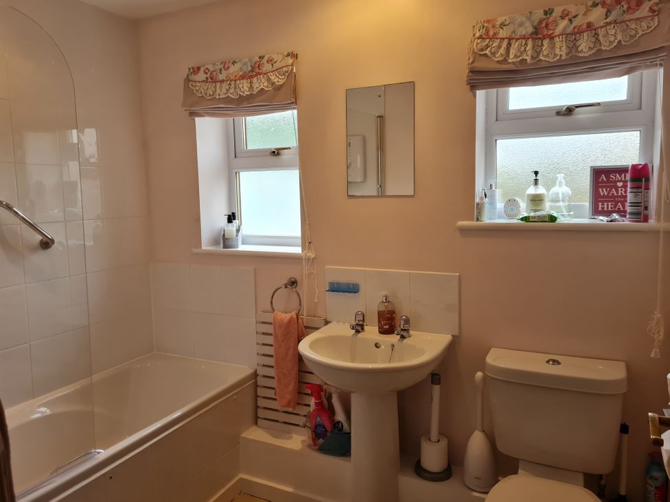 A bathroom featuring a bathtub, sink, and toilet at Riverside cottage with otters near Tintagel