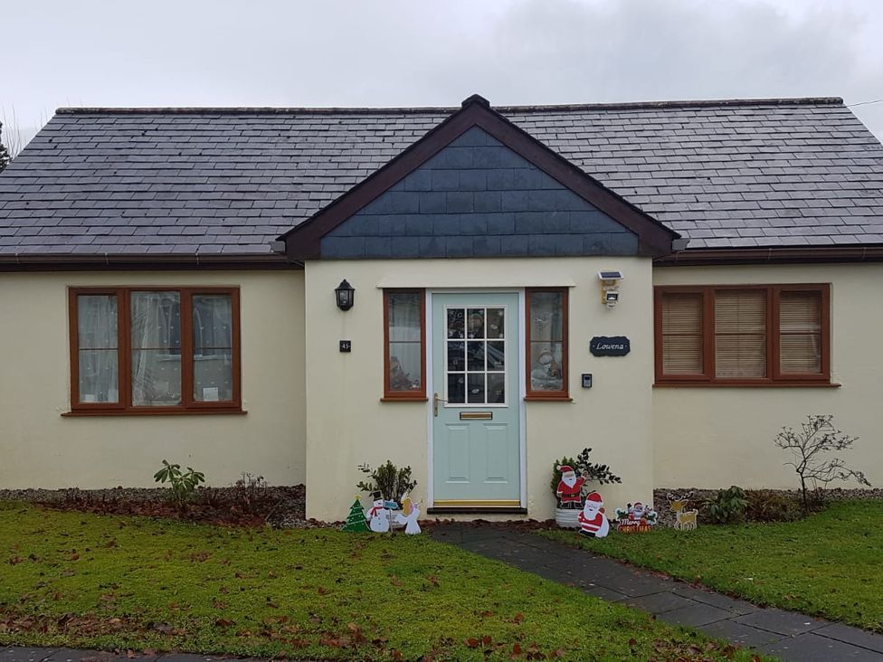 A house with a front door and lawn at Riverside cottage with otters near Tintagel