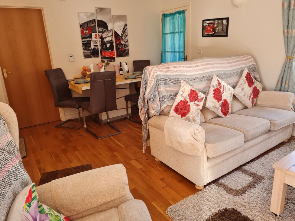 A living room with a couch and dining area at Riverside cottage near Tintagel in Camelford