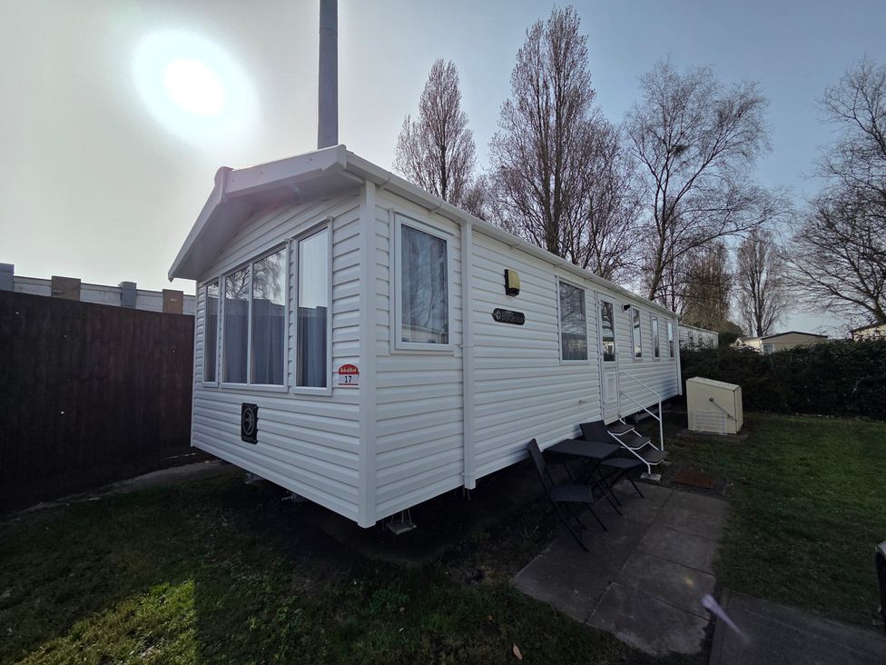 A mobile home exterior with windows and a lawn at Beach holiday base with pool and kids' activities