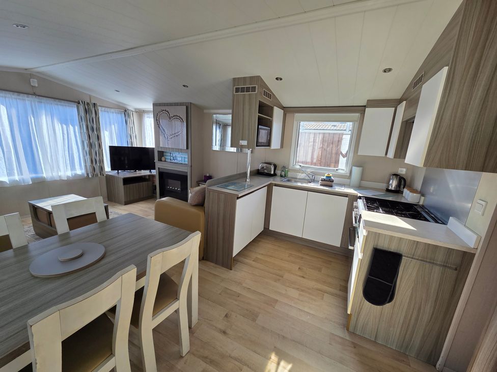 A kitchen with appliances and seating area at Beach holiday base with pool and kids' activities