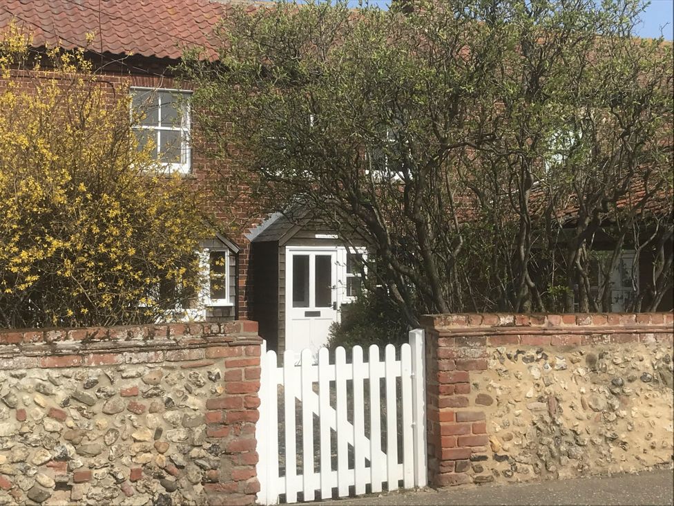A house with a white gate and bushes at tbc in 