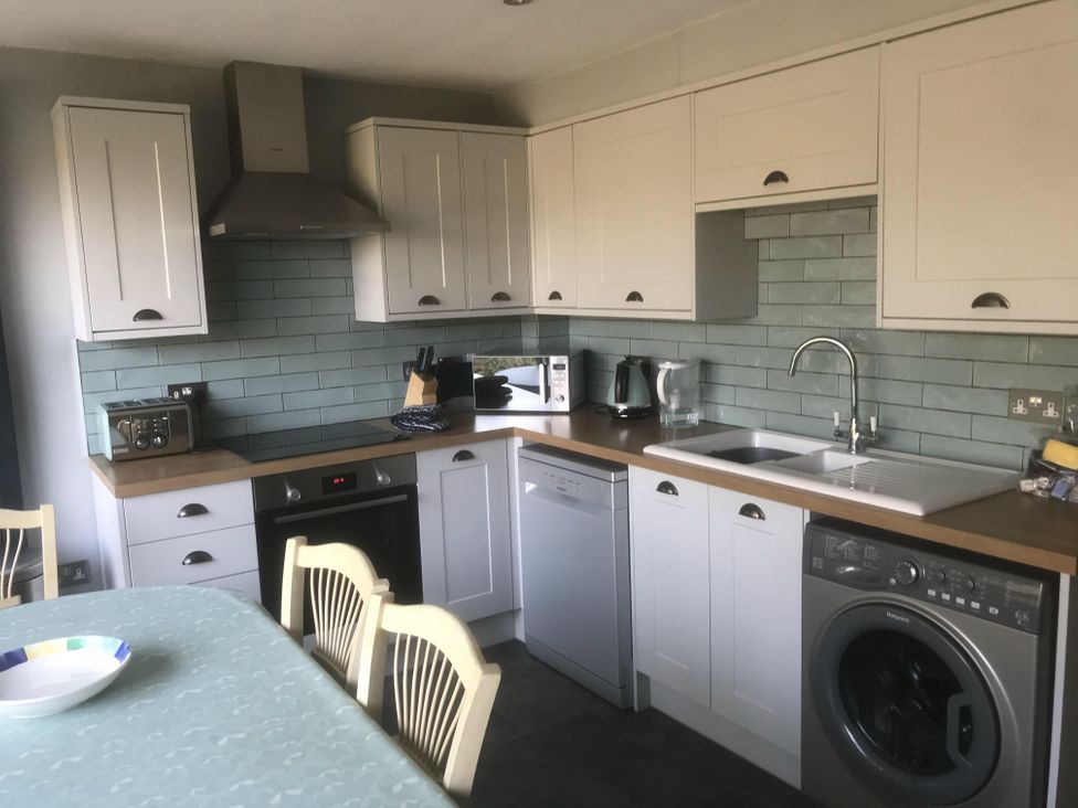A kitchen with a washing machine and dishwasher at tbc 